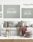 A living room with white walls showcasing different canvas print sizes. A sofa in the center is adorned with various pillows and throws. Above, three pieces of ready-to-hang canvas wall art display their sizes: 11x14, 16x20, 24x32, and *30x40 Rustic Canvas Print (Choose from 10+ Designs) by Offley Green*. Text reads "Canvas Print Sizes.