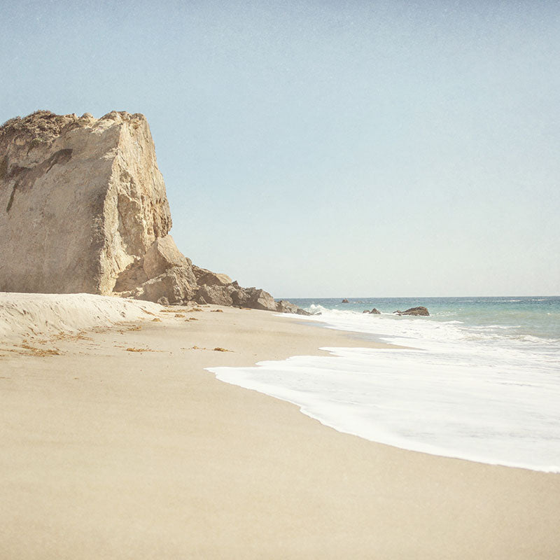 Photographic print of Dume point in Malibu, the tall cliff rises above the crashing waves in this dramatic coastal scene