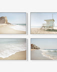 The Set of 4 Framed Canvas by Offley Green is arranged in a grid, showcasing beach scenes. The top left canvas depicts a rocky cliff by the ocean, while the top right features a lifeguard tower. The bottom left canvas captures gentle waves on the shore, and the bottom right exhibits a beachfront with houses that evoke relaxing coastal styles.