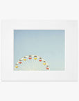 A 'Ferris Blue' ferris wheel with colorful cabins set against a clear blue sky, framed within a white border on archival photographic paper by Offley Green.