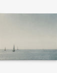 A serene seascape featuring several sailboats scattered across a calm, expansive sea under a pale, hazy sky. The horizon blends softly with the sky, creating an atmosphere of tranquility and open space—a perfect scene for the Offley Green 24x30 Coastal Canvas Print (Choose from 10+ Designs) presented as canvas gallery wraps.