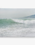 A serene coastal scene capturing a gentle wave rolling towards a sandy shore under an overcast sky. In the background, a misty hillside meets the horizon, blending seamlessly with the calm sea. Introducing the 11x14 Coastal Canvas Print from Offley Green—part of a collection featuring over 10 beautiful designs. These canvas gallery wraps are ready to hang and transform any space.