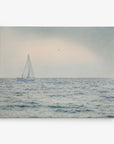 A serene seascape featuring a solitary sailboat with white sails gliding on calm waters under a hazy sky. Three birds are flying in the distance, enhancing the peaceful and tranquil atmosphere. This beautiful scene is captured on Offley Green's 11x14 Coastal Canvas Print (Choose from 10+ Designs) and comes ready to hang, making it perfect for any space.