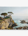 A coastal scene featuring rocky cliffs with two wind-swept trees perched on top, overlooking a vast ocean. The waves crash against the rocks, and the sky is a pale blue with a few wispy clouds. This serene and picturesque view would make stunning wall art as an Offley Green 8x10 Coastal Canvas Print (available in over 10 designs).