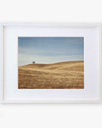 A framed photograph depicting a serene landscape in Santa Ynez Valley with rolling hills covered in dry grass and a solitary tree under a clear sky - Offley Green's California Central Coast Landscape Print 'Golden Ynez'.