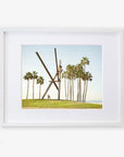 Framed artwork depicting the Venice Beach Landmark Sculpture, 'V is for Venice' by Offley Green, with large scissors cutting through the air and palm trees in the background of Venice Beach under a clear sky.