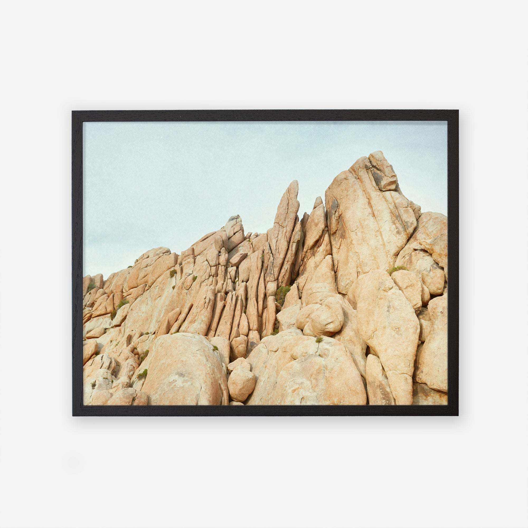A framed photograph of a rugged, rocky landscape showcasing a cluster of large, weathered boulders under a clear sky in Joshua Tree.
Product Name: Offley Green&#39;s &#39;Joshua Rocks&#39; Print