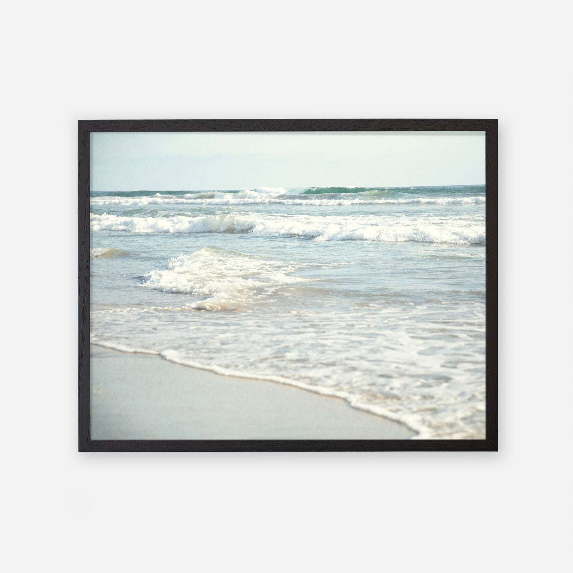 Framed photograph of Carlsbad State Beach showing gentle waves breaking on the shore with a clear view of the ocean extending toward the horizon featuring the Coastal Beach Print in California &#39;Surf and Sun&#39; by Offley Green.