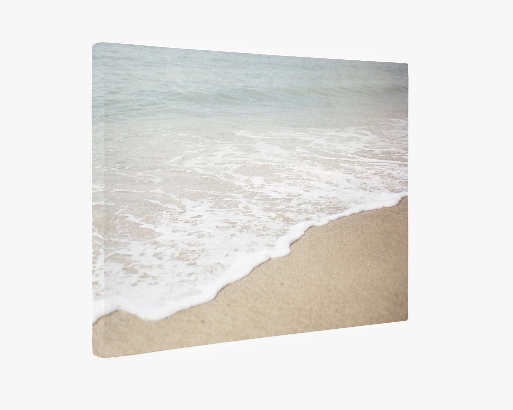 A minimalist artwork depicting gentle ocean waves lapping against the sandy shores of Will Rogers State Beach, mounted on a premium artist-grade canvas. The colors are soft and muted, creating a serene and calming visual effect. This is the Beach Waves Canvas Wall Art, 'Chasing Surf' by Offley Green.