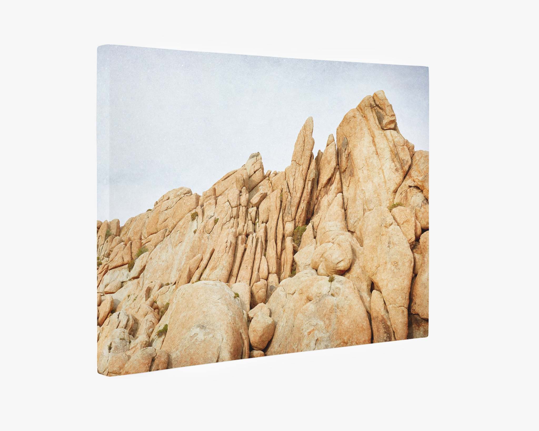 Offley Green Joshua Tree Canvas Wall Art, 'Joshua Rocks' featuring a rugged, rocky desert scene with large, weathered yellow desert rock formations set against a pale sky. The jagged rocks dominate the frame, displaying varied textures and natural erosion, reminiscent of mid-century Palm Springs.